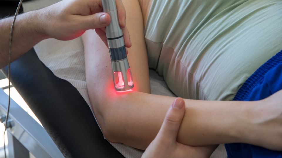 Laser therapy for elbow pain woman on table