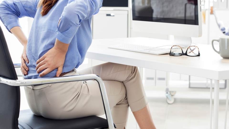 woman sitting with back pain dublin physio