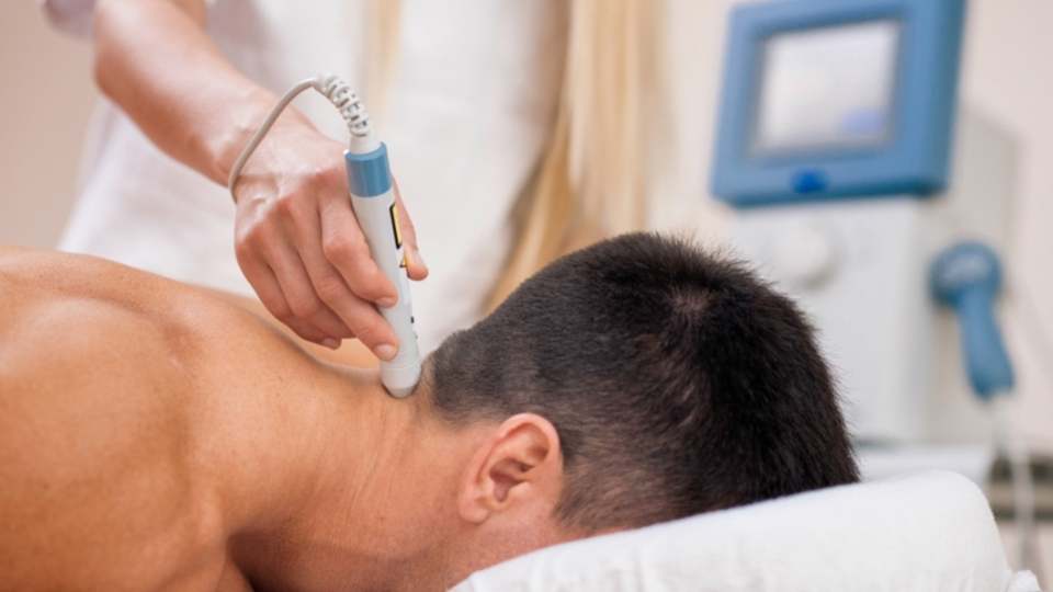 man getting laser therapy for neck pain